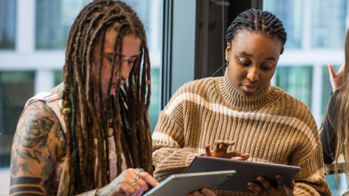 Two women looking at their Ipads